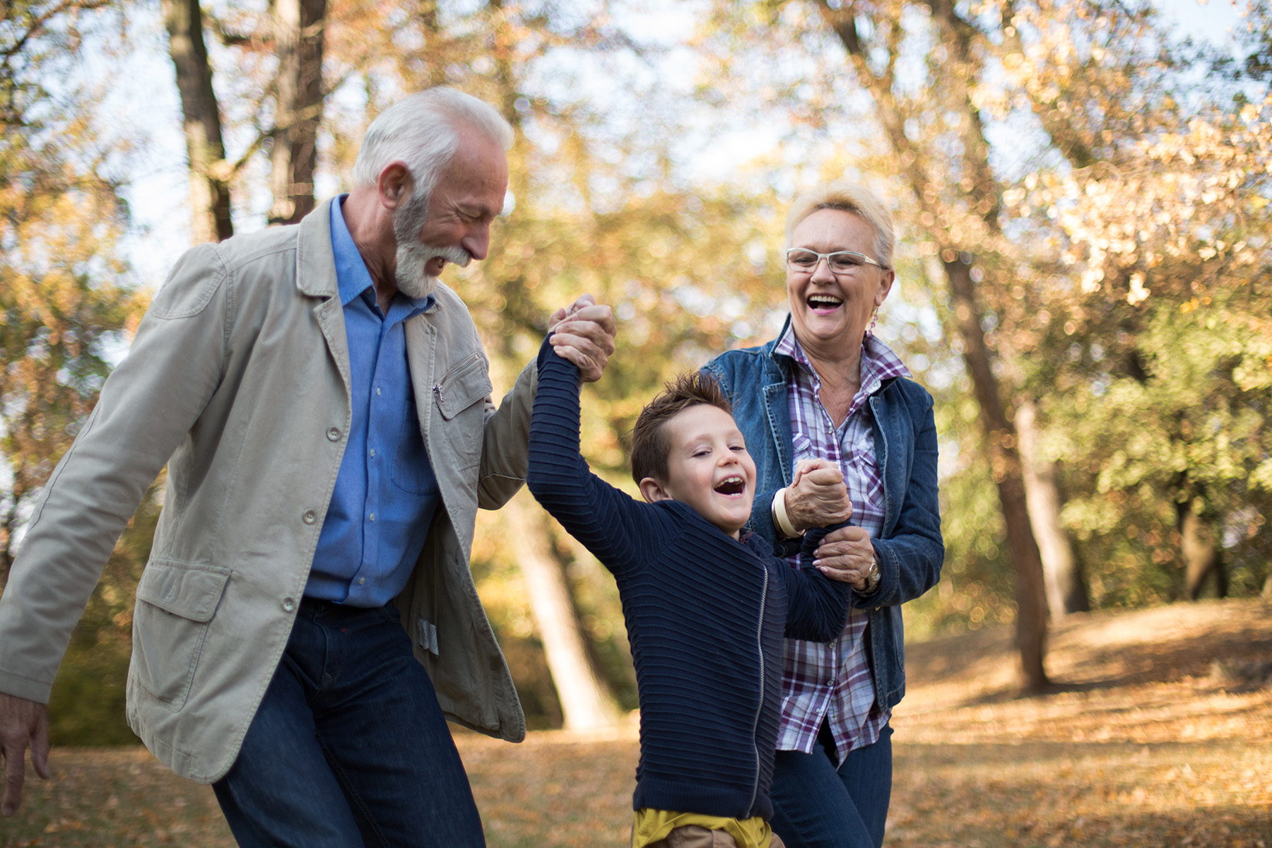 Grandparents playing with their grandchild in the park